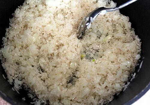 agregue el arroz y cocine a fuego lento en aceite