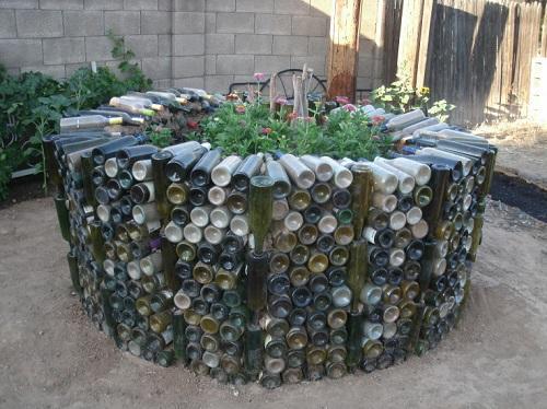 un macizo de flores de botellas de vidrio a base de