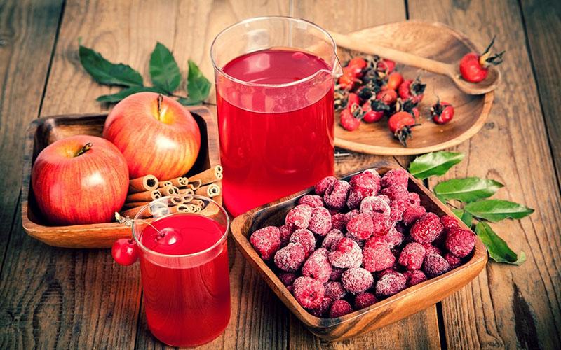 recette de jus de pomme pour l'hiver à travers un presse-agrumes aux framboises