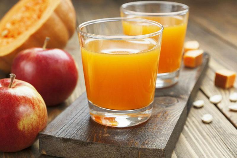 recette de jus de pomme pour l'hiver à travers un presse-agrumes citrouille