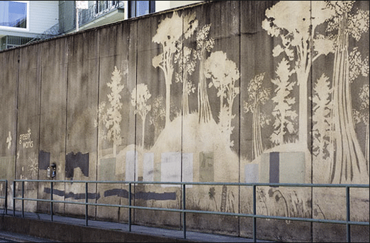 Dieses Baumwandbild hat dieser schmuddeligen Straßenmauer definitiv Leben eingehaucht.