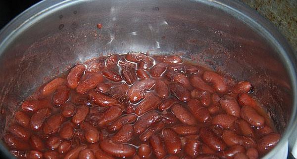 cocinar los frijoles hasta que estén medio cocidos