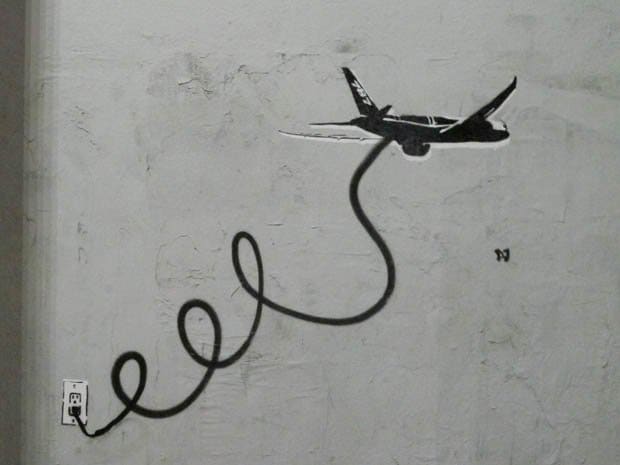 Fly By Wire - Los Angeles Pouliční umělec - PLASTIC JESUS ​​se ohlíží po problémech Boeingu s vlajkovou lodí 787 Dreamliner společnosti Boeing. Šablony graffiti spatřené v Los Angeles & apos; Melrose distict zobrazuje letadlo připojené k elektrické zásuvce kabelem k překonání elektrických problémů, které letadlo uzemnily.