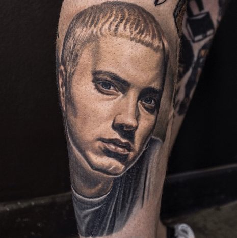 Tätowierung von Nikko Hurtado. Eminem machte sich 1999 mit seinem ersten Album The Real Slim Shady LP einen Namen. Die Platte wurde mehrfach mit Platin ausgezeichnet. Sein zweites Album The Marshall Mathers LP wurde im Jahr 2000 veröffentlicht und wurde zu dieser Zeit das am schnellsten verkaufte Rap-Album. Neun Alben später (8 Mile, Encore, Recovery usw.) erschien 2013 The Marshall Mathers LP 2. Heute erstellt er den Soundtrack für den Film Southpaw mit Jake Gyllenhaal und 50 Cent.