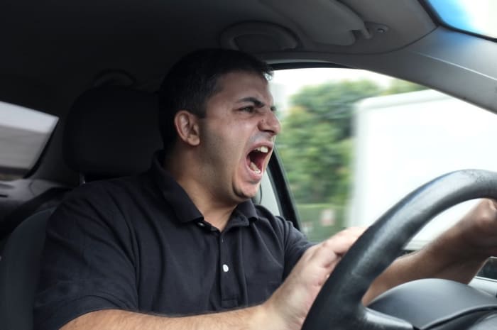 رجل غاضب يقود سيارته مع غضب الطريق