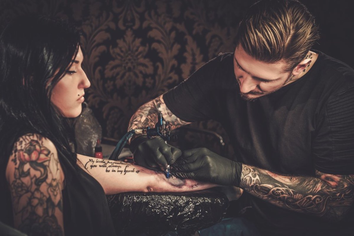hezká dívka se nechává tetovat pohledným umělcem