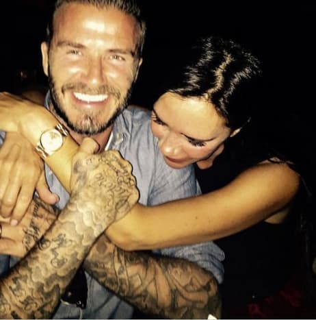 Victoria Beckham sieht sich die Tattoos ihres Mannes David genau an.