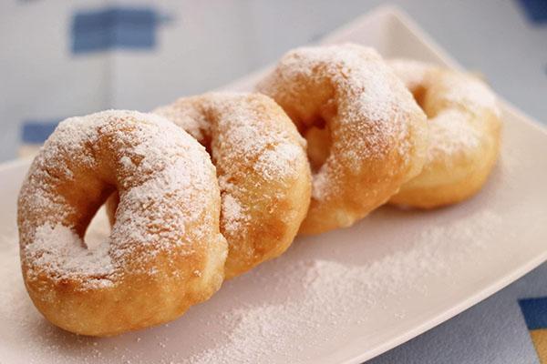 saupoudrer les beignets de sucre en poudre