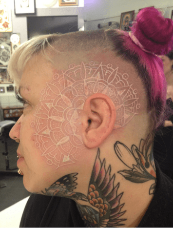 Foto via tat trendsDieses große, aber subtile Stück in weißer Tinte passt gut zu Kopf und Gesicht dieses Mädchens.