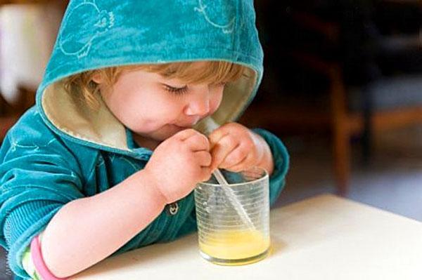 enfant boit du jus de pommes