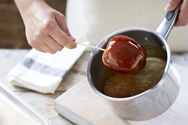 sumerja las manzanas en caramelo caliente