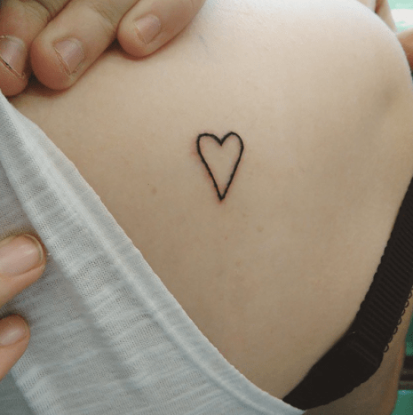 Tetování s malým srdcem v náhodném místě.