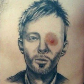 Wir sind nicht 100%ig, ob dieser Typ ein großer Radiohead-Fan ist oder sich einfach nur über Thom Yorke lustig macht, aber dieses Tattoo bringt uns jedes Mal zum Lachen, wenn wir es sehen.