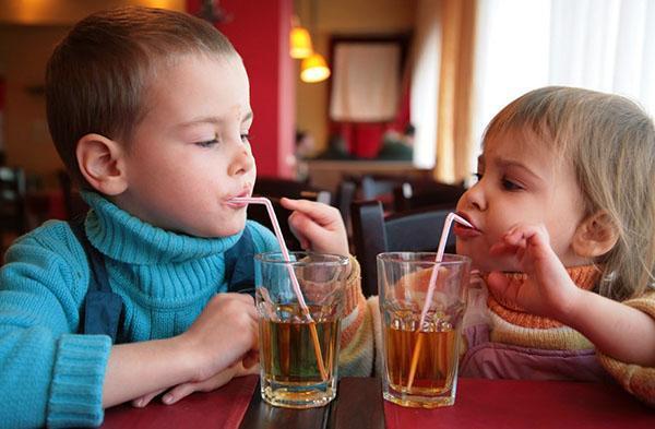 los niños beben jugo de manzana