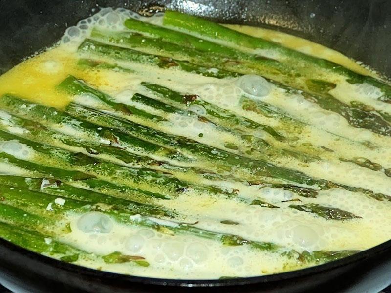 verser la sauce et les œufs sur les asperges