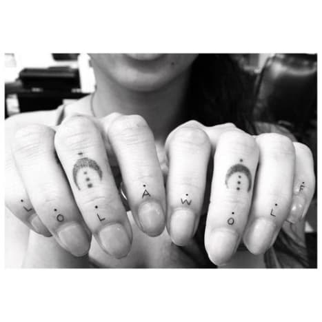 Foto: Dr. Woo/InstagramKravitz hat bereits einige Blinzel-und-du-vermisst-Tätowierungen an ihren Händen, darunter eine kleine Basquiat-Krone an der Basis ihres rechten Mittelfingers, Halbmonde auf beiden Mittelfinger und winzige schwarze Großbuchstaben mit der Aufschrift „Lola“ und „Wolf“ an der Basis ihrer Fingernägel, wobei jeder Buchstabe von einem kleinen schwarzen Punkt begleitet wird. Lola ist für Kravitz' Schwester Lola Iolani Momoa und Wolf für ihren Bruder Nakoa-Wolf Momoa. Zusammen bilden die Namen auch Kravitz' Band Lolawolf. Diese neuesten Tattoos sind in die Mitte des Handrückens von Kravitz eingefärbt, wobei die Spitzen der Blätter zu ihrem Körper und die Stiele zu ihren Fingern zeigen.